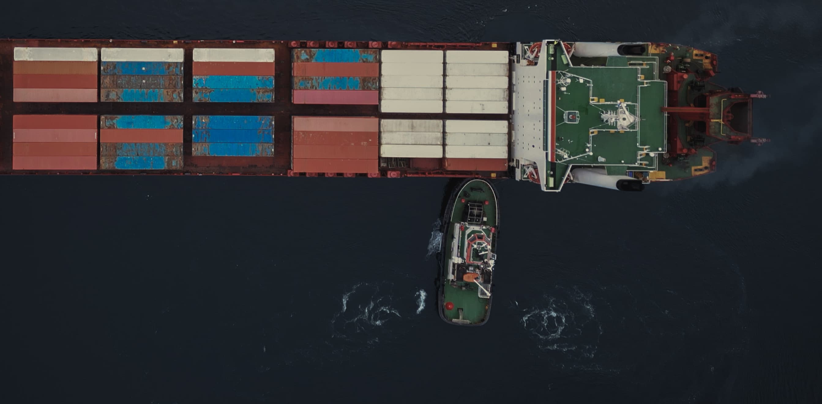 Ein Schlepper, der einen Ozeanriesen manövriert