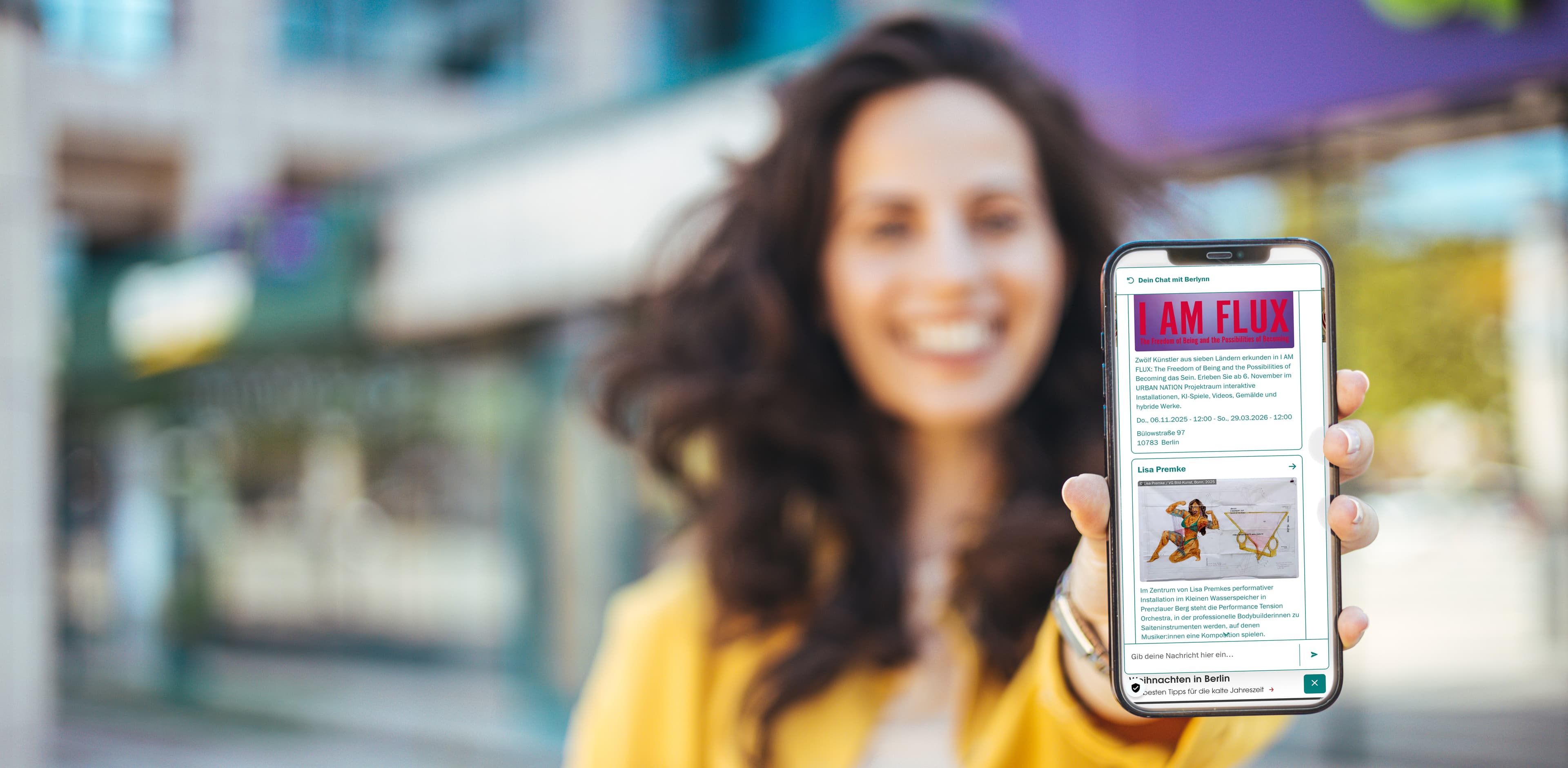 Junge Frau die Ihr Handy mit dem Berylinn Chat-Bot in die Kamera hält
